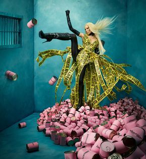 a woman in a room full of pink and yellow tape wrapped around her body, surrounded by lots of objects