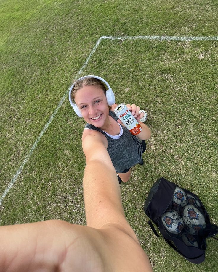 a woman is taking a selfie with her cell phone while holding onto a water bottle