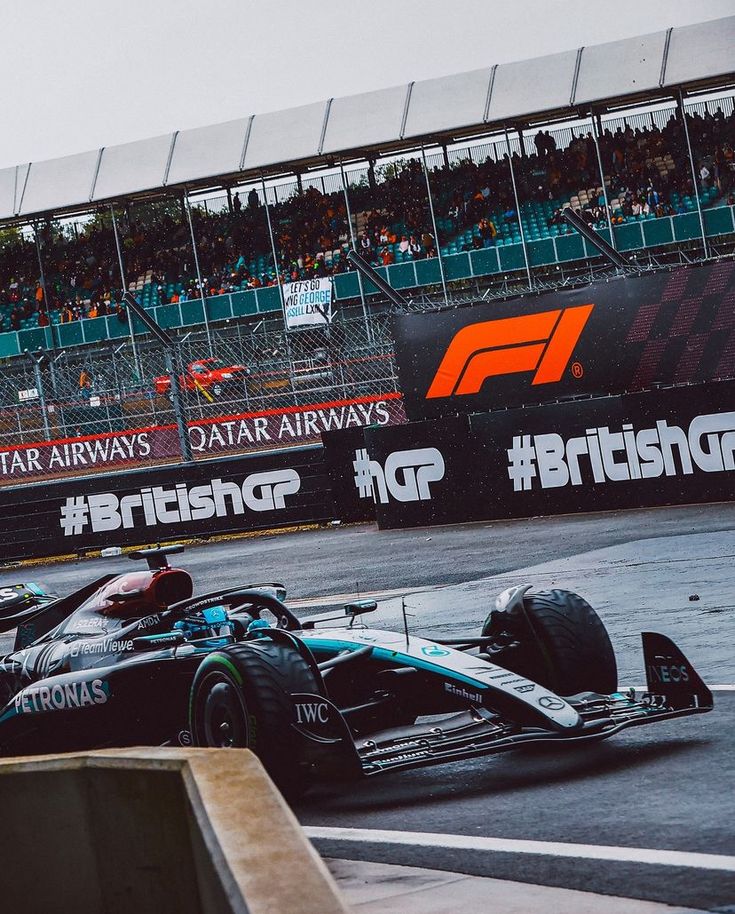 two racing cars on the track in front of an audience