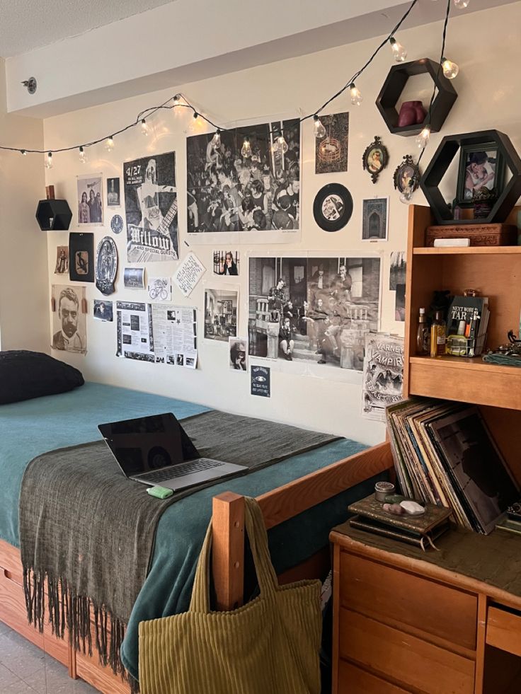 a bed room with a neatly made bed and lots of pictures hanging on the wall