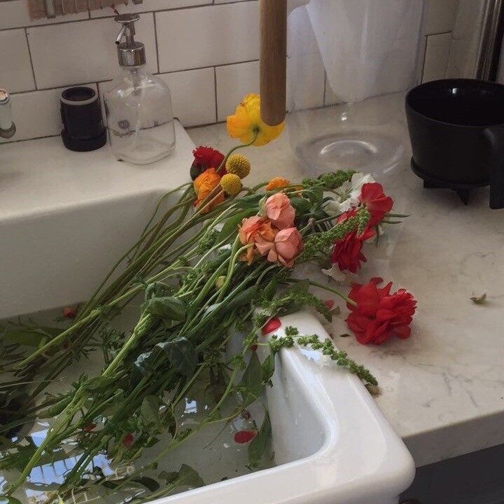 some flowers are sitting in the sink with water