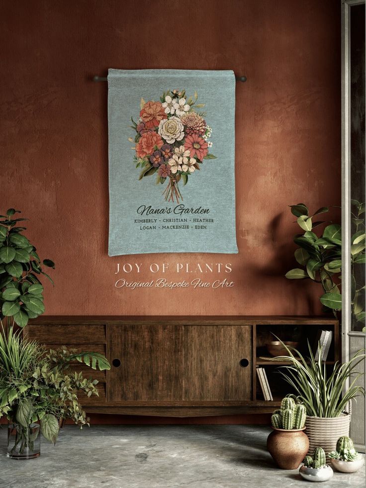 a wall hanging on the side of a wooden cabinet next to two potted plants