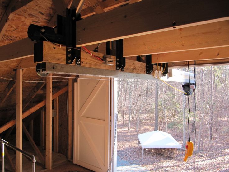 the inside of a house being built with wood framing and metal bars hanging from the ceiling