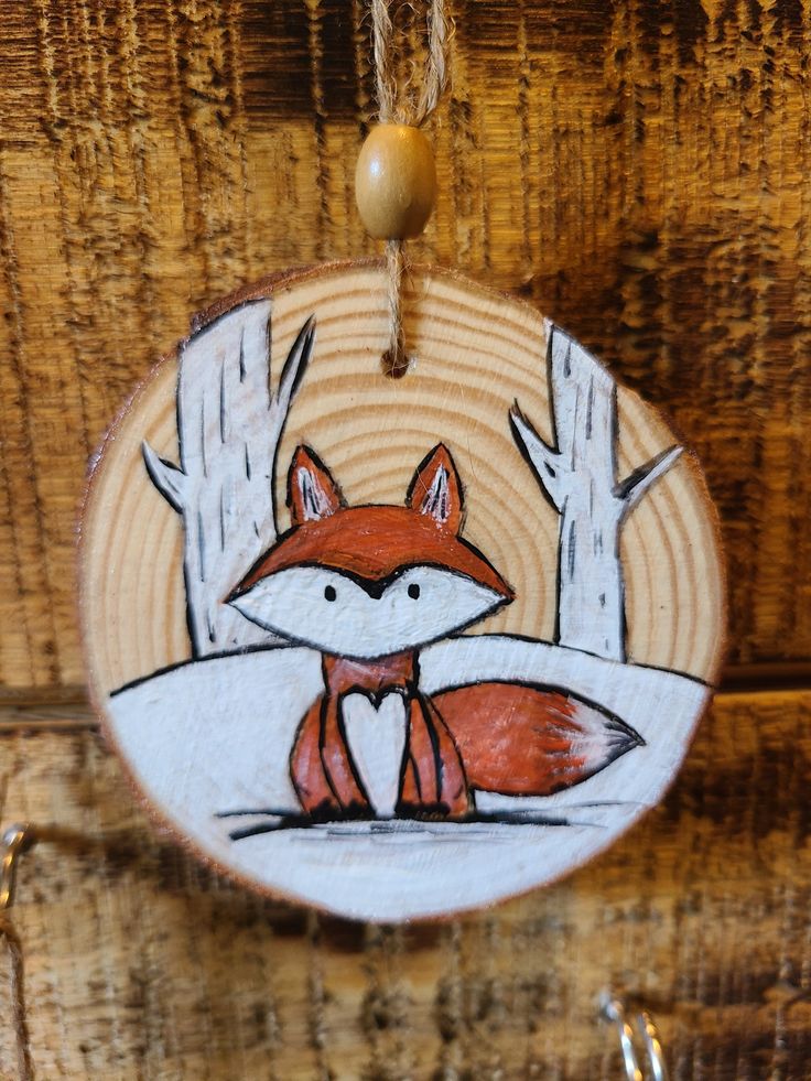 a wooden ornament with a red fox on it