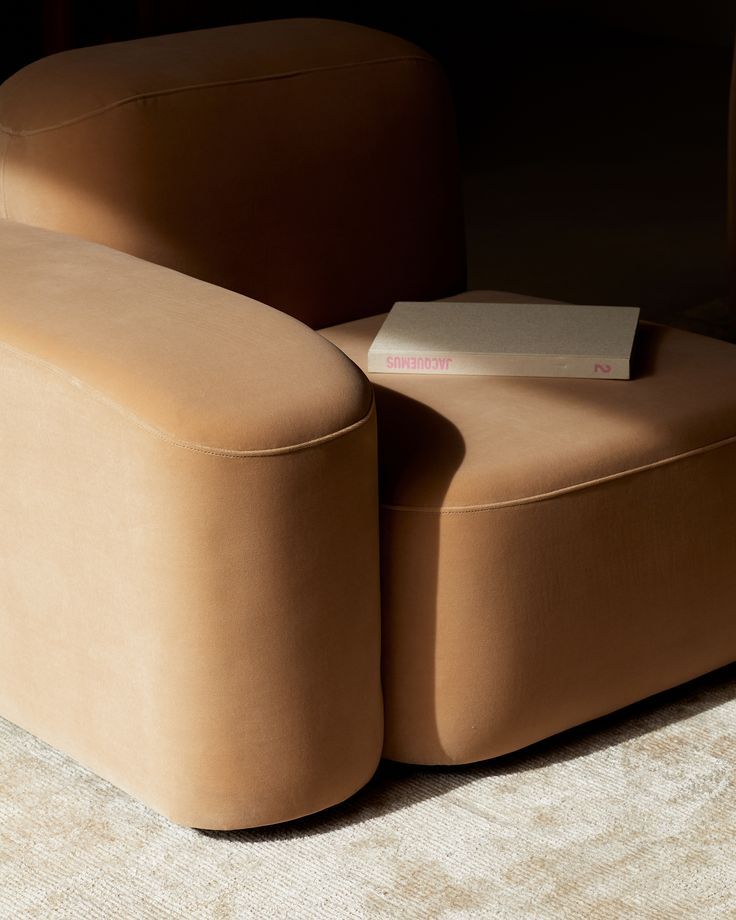 a tan chair with a book on it