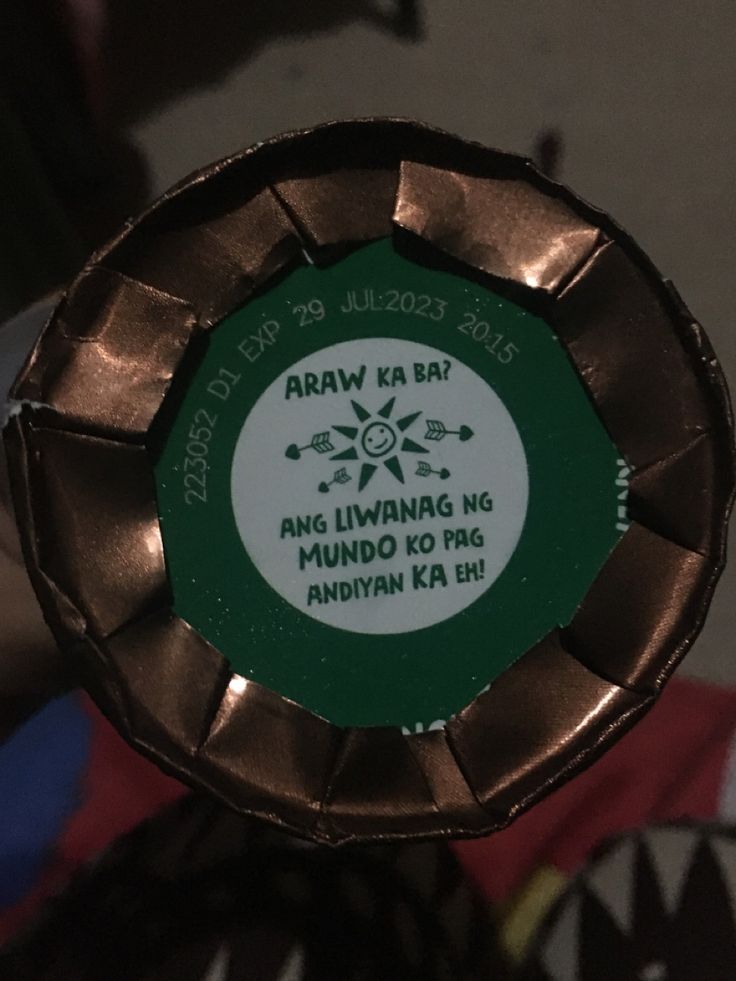 a close up of a green and white label on a metal object with words in it