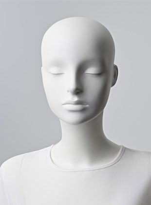 a white mannequin head with closed eyes and no hair on it's head