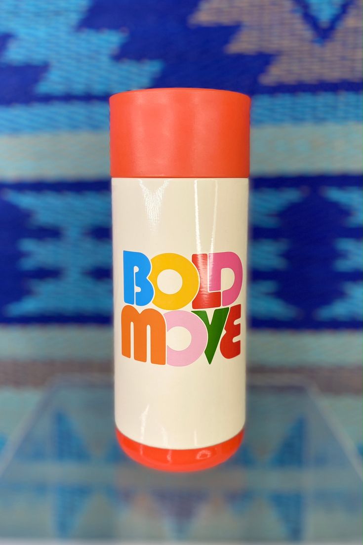 an orange and white coffee cup with the word bold move on it's side