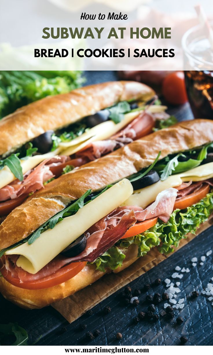 two sandwiches with meat, cheese and lettuce are on a cutting board next to salads