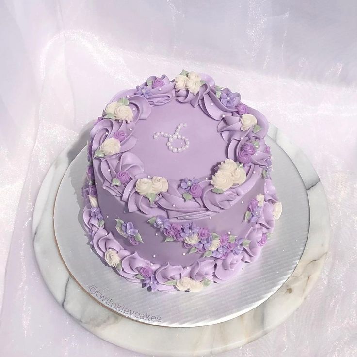 a purple cake decorated with flowers on a plate