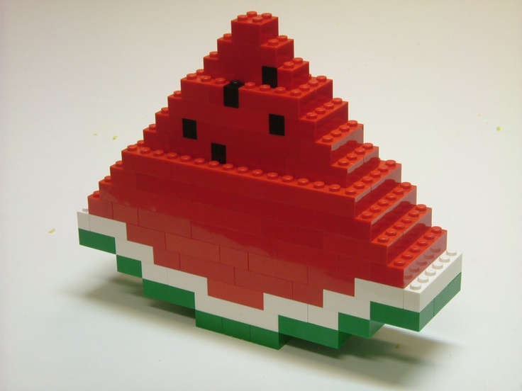 a red and green lego piece sitting on top of a white table