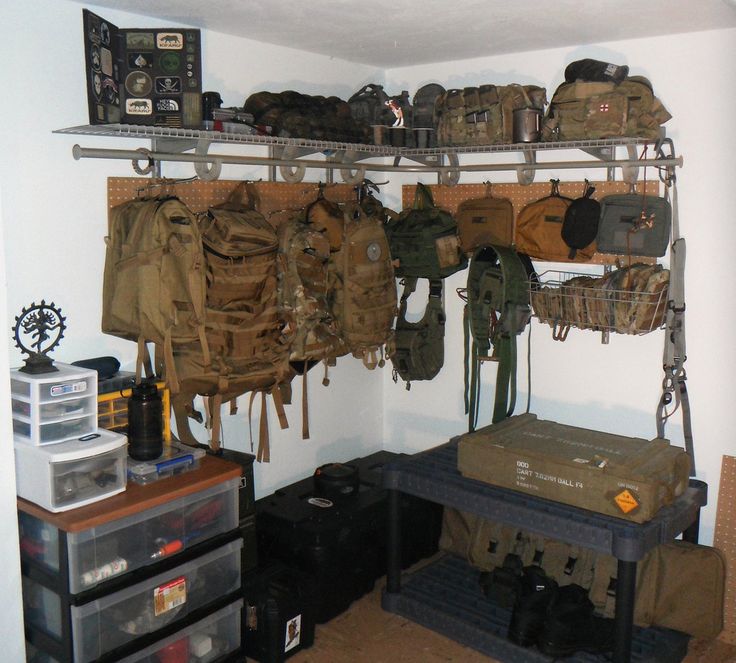 there are many backpacks hanging on the wall in this room, and one is empty