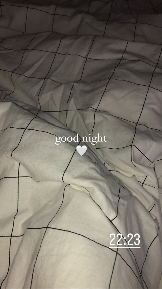 an unmade bed with the words good night written on it and a white heart