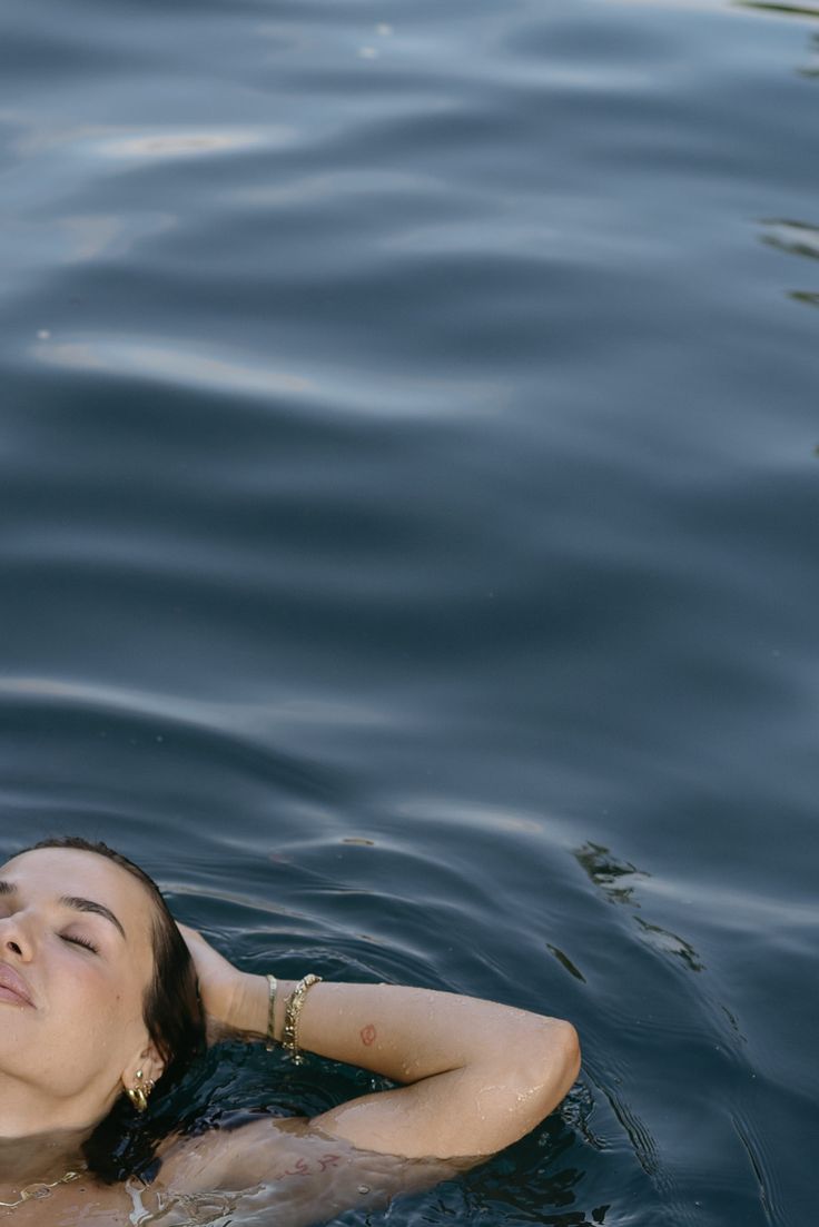 a woman floating on top of a body of water