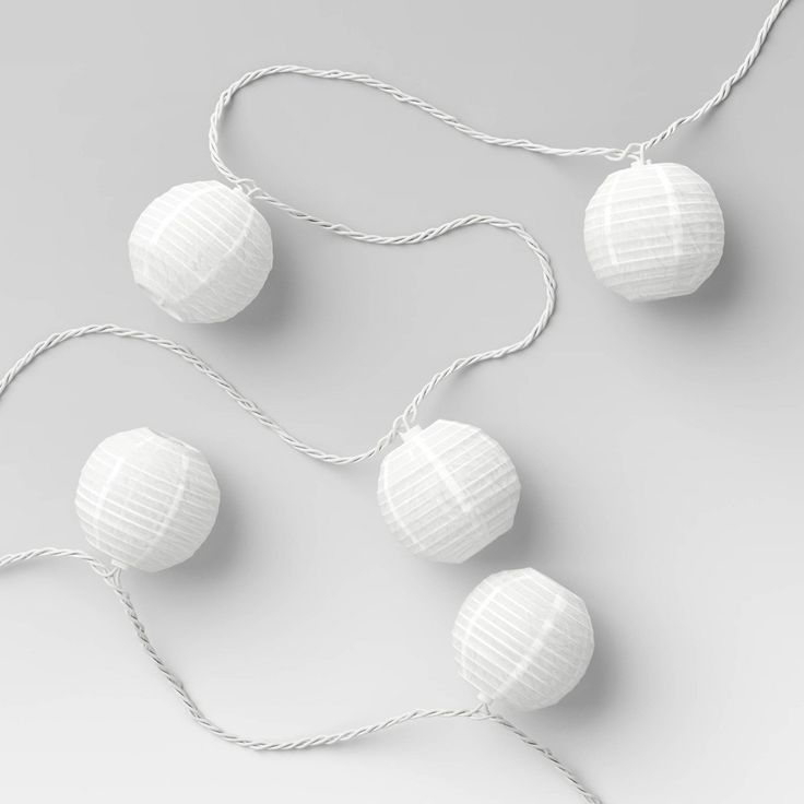 three white paper lanterns hanging from string