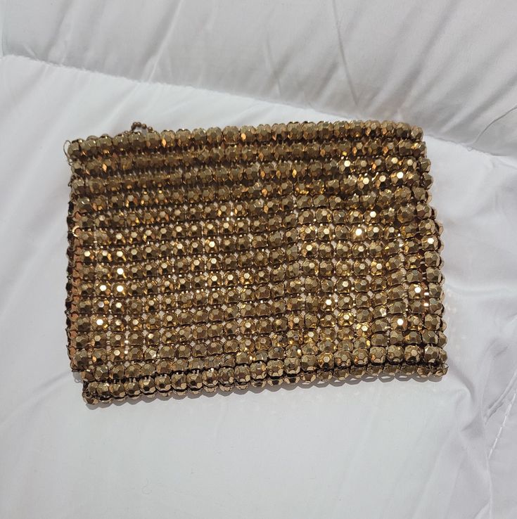 Lovely antique Whiting and Davis gold mesh coin purse.  This little purse is uncommon, and the mesh is made of 3-D raised square gold beads.  It is a weighty little bag.  The gold has darkened, and the purse has the patina of age.  The bag has a zipper and a chain pull, and bears the Whiting and Davis label on the inside lining.  It measures  4" by 5" and is in good pre-owned condition for a piece this age. Luxury Vintage Clutch Coin Purse, Gold Square Evening Bag, Rectangular Gold Evening Bag, Vintage Gold Coin Purse For Party, Vintage Handmade Gold Coin Purse, Vintage Gold Handmade Coin Purse, Handmade Vintage Gold Coin Purse, Gold Rectangular Clutch For Fashion Accessory, Handmade Gold Coin Purse For Parties