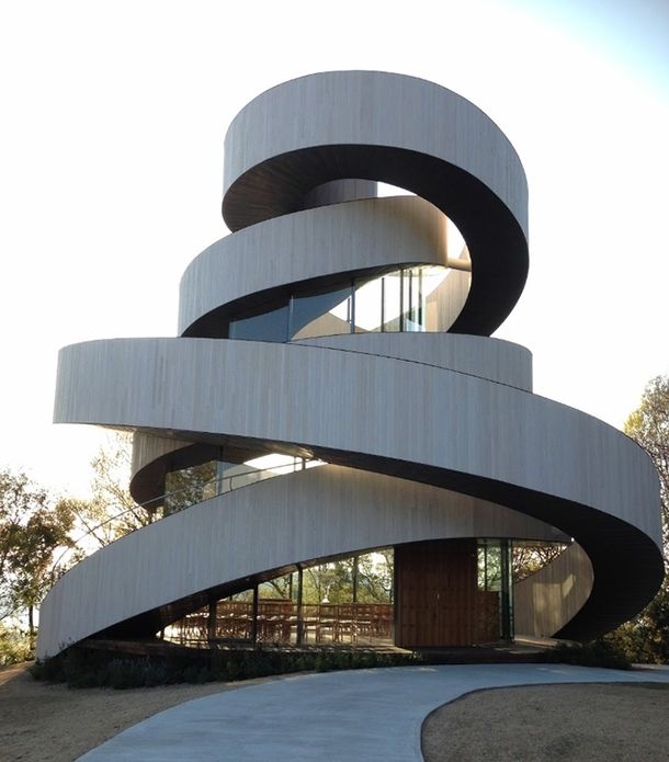 a large spiral shaped building in the middle of a park