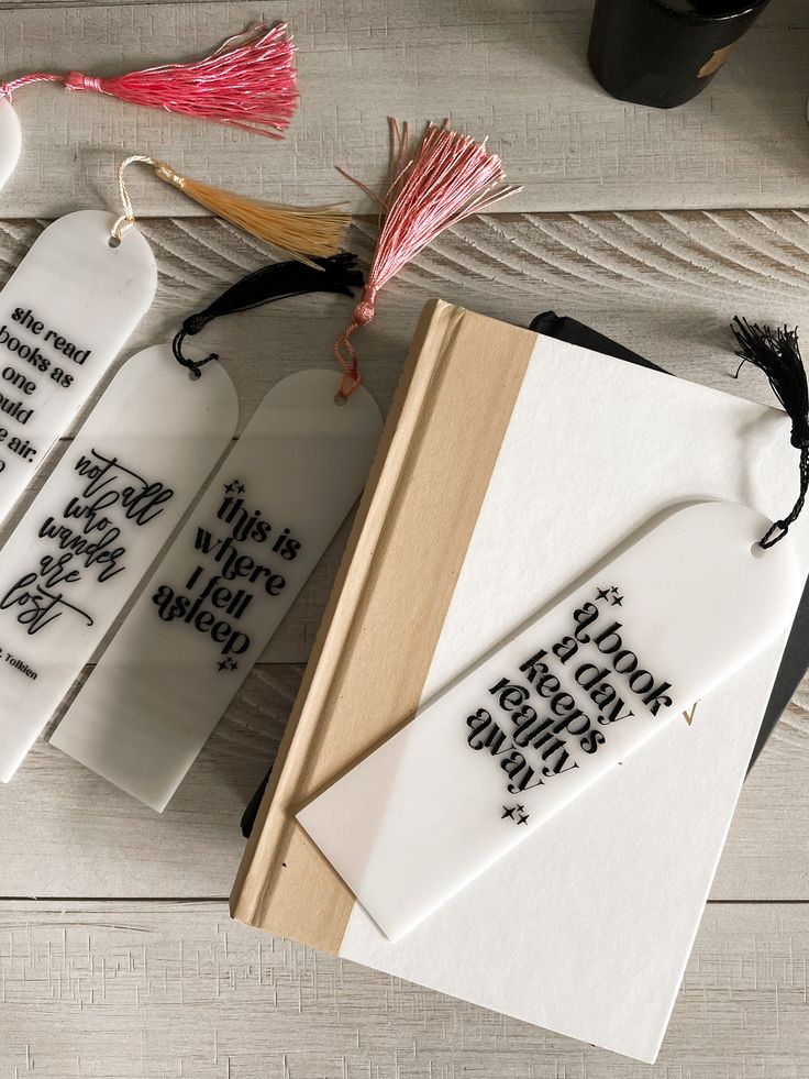 three bookmarks with words on them and tassels