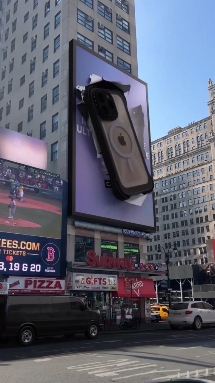 an advertisement on the side of a large building in a city with cars driving by