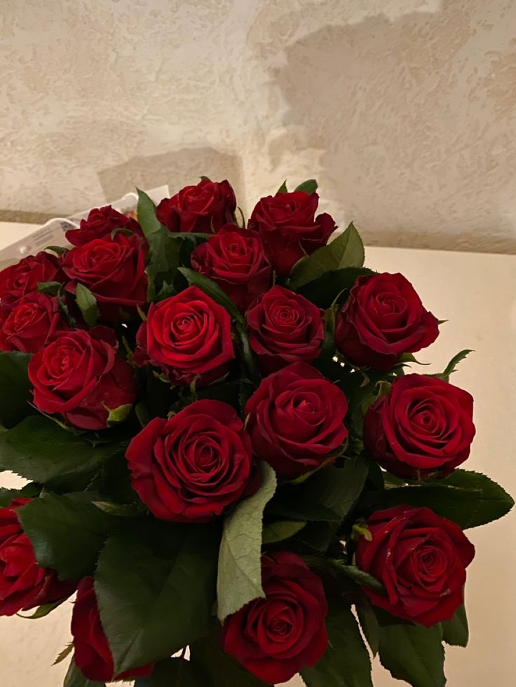 a vase filled with red roses on top of a table