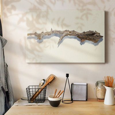 a wooden table topped with bowls and utensils next to a painting on the wall