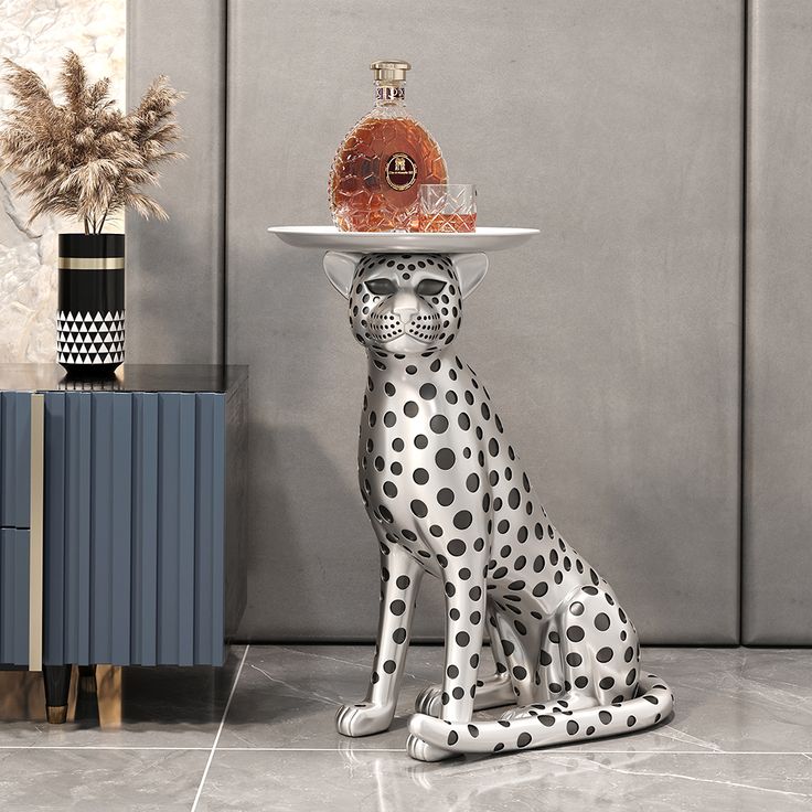 a black and white cat with a hat on it's head sitting next to a table