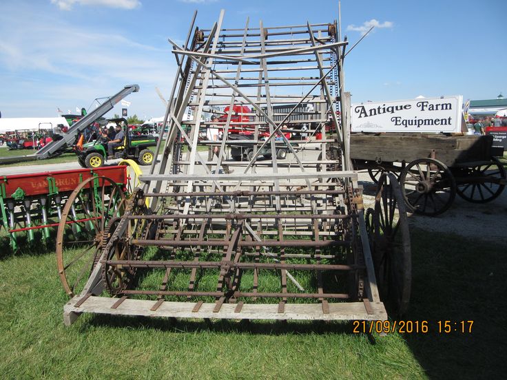 an antique farm equipment display in the grass