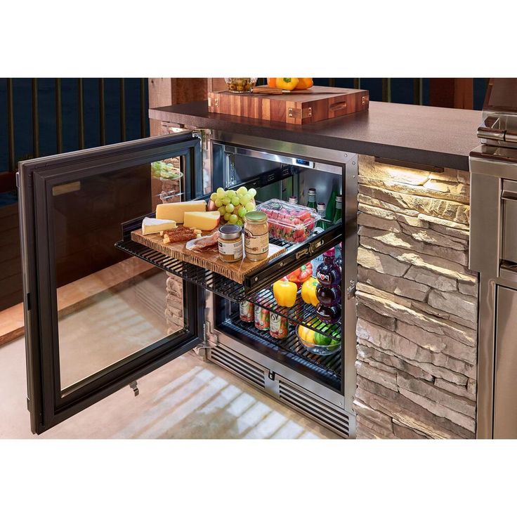 an open refrigerator filled with lots of food next to a counter top freezer oven