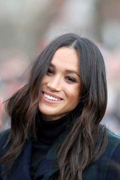 a woman with long dark hair smiles at the camera