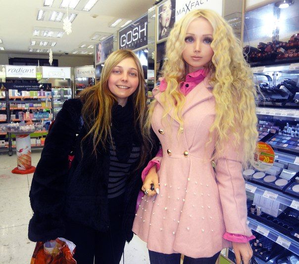 two women standing next to each other in front of a store display with mannequins