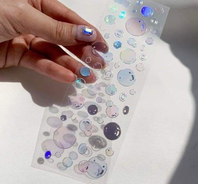 a person's hand holding onto a sticker with lots of bubbles on it