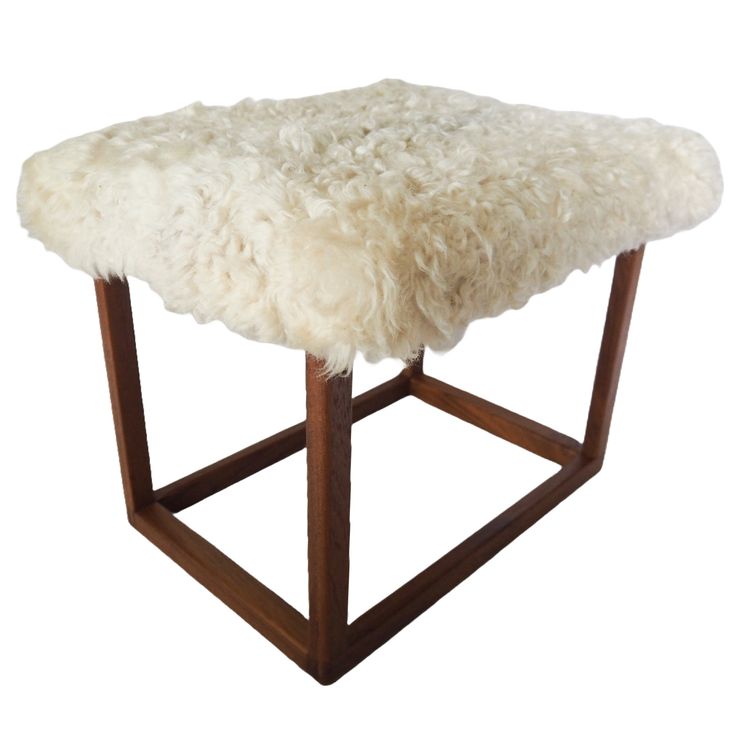 a sheepskin stool with wooden legs on an isolated white background