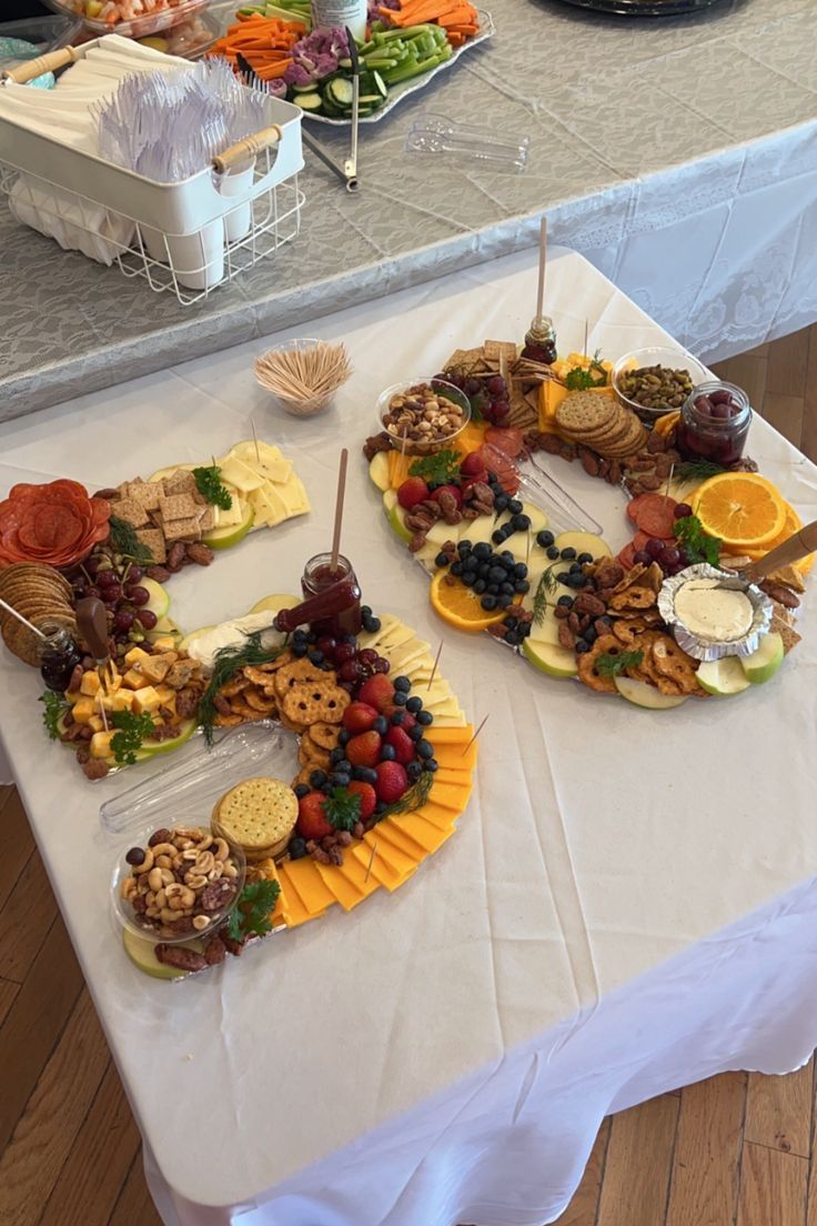 a table topped with lots of food on top of a white tablecloth covered table