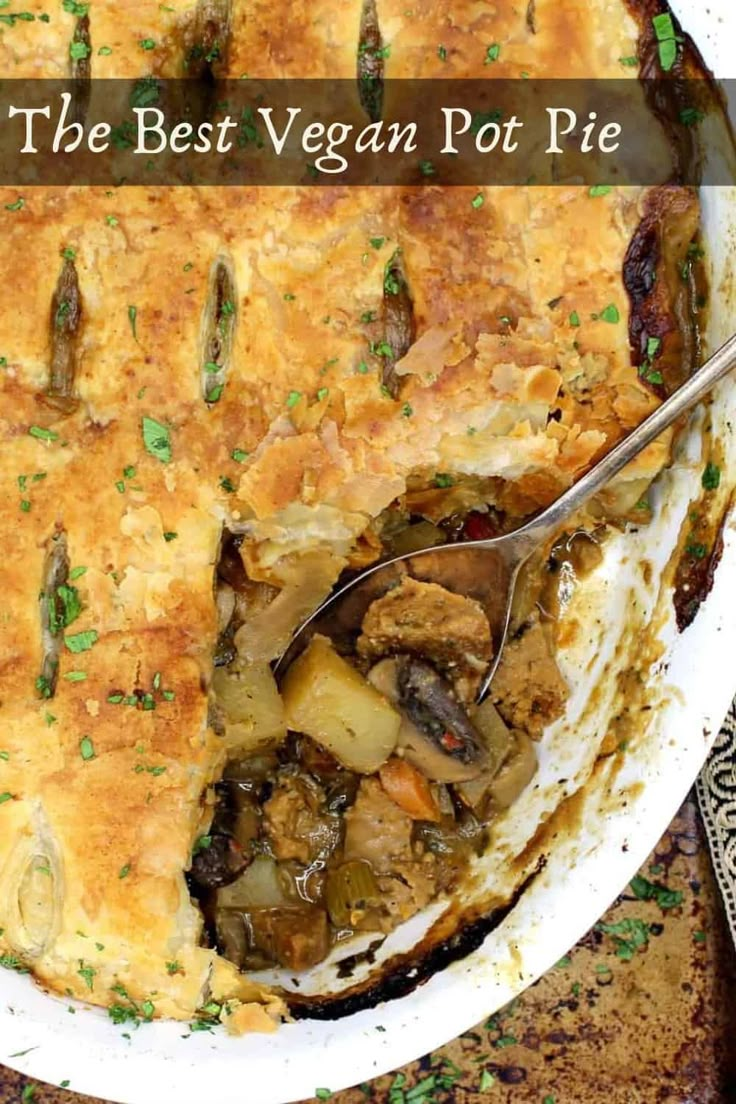 the best vegan pot pie is in a white dish with a serving spoon inside