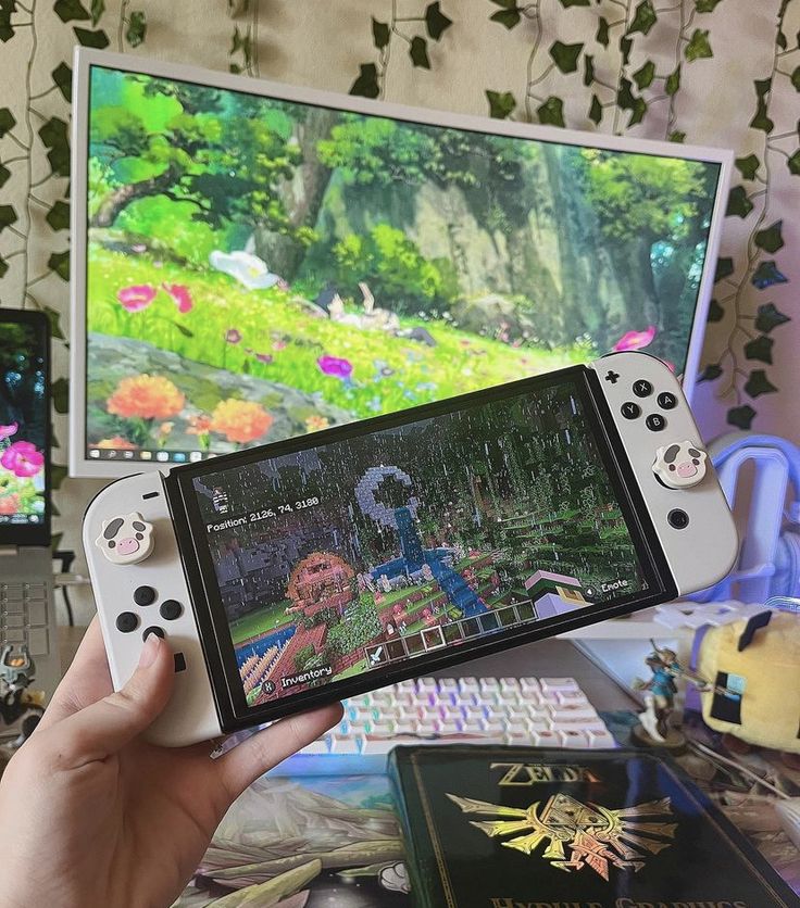 a person holding a nintendo wii game controller in front of a computer screen with the legend of zelda on it