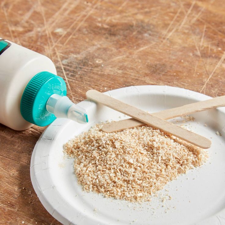 a white plate topped with lots of dirt next to a bottle