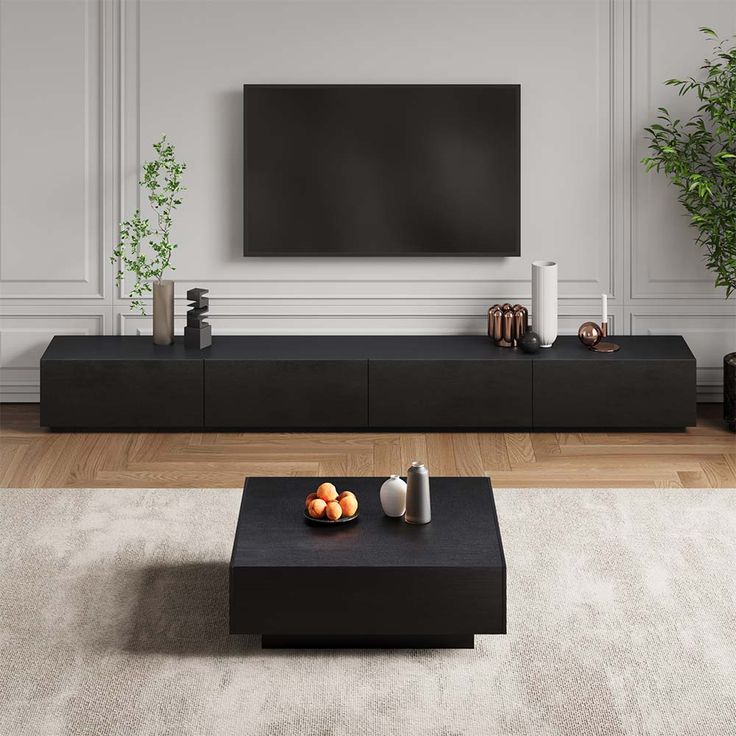 a modern living room with white walls and wood flooring, black coffee table in front of the flat screen tv