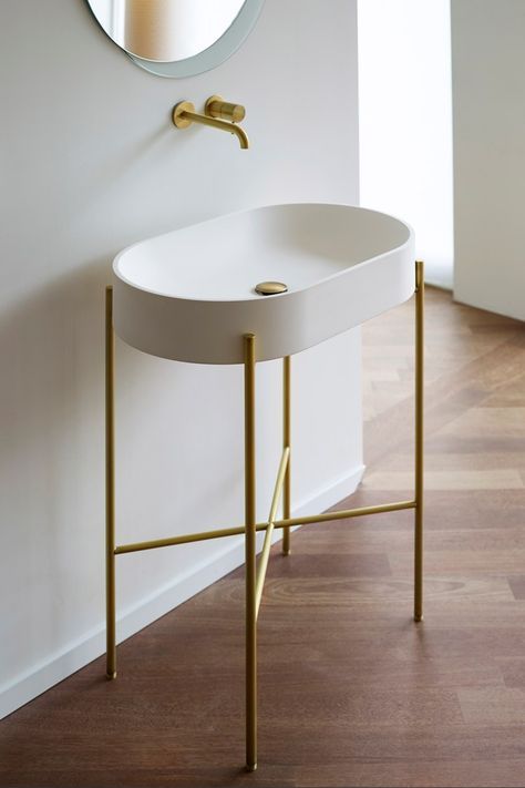 a white sink sitting under a mirror next to a wooden floor