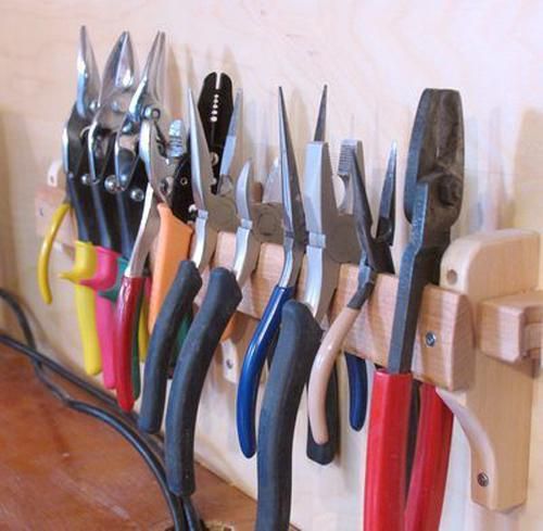 there are many pairs of scissors hanging on the pegs in front of a wall