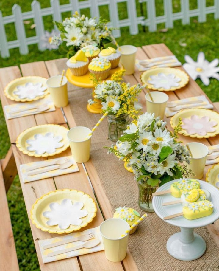 a wooden table topped with yellow and white plates