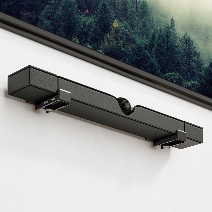 a black shelf mounted to the side of a white wall with trees in the background