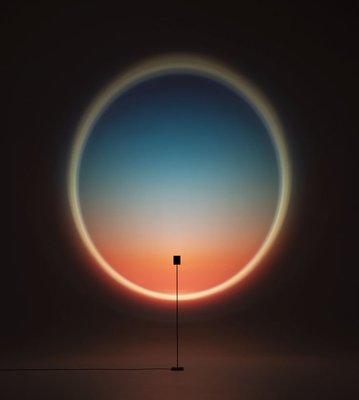 an orange and blue circle with a light pole in the middle, against a dark background