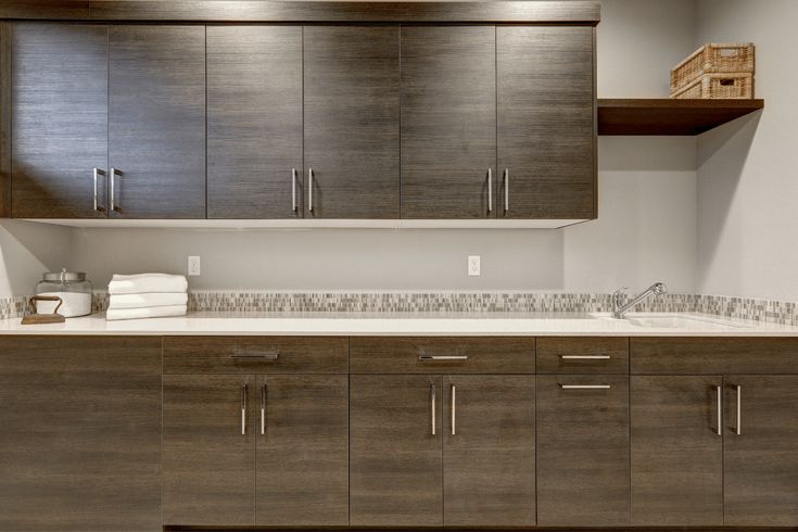 an empty kitchen with wooden cabinets and white counter tops