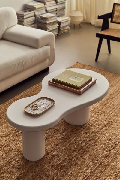 a white coffee table sitting on top of a rug in a living room next to a couch