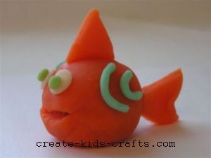 an orange toy fish with green eyes on it's head