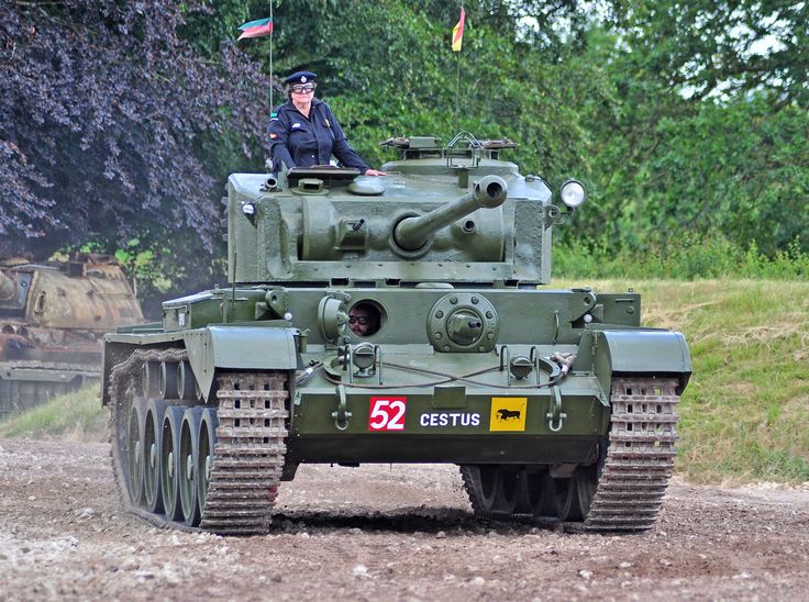 a man is sitting on top of a tank in the middle of a dirt road