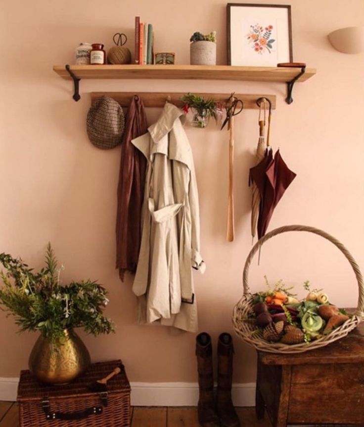 a wooden bench sitting in front of a wall mounted coat rack