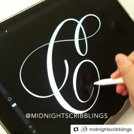 a person is writing on an ipad with a white pen and it has the letter c in cursive writing