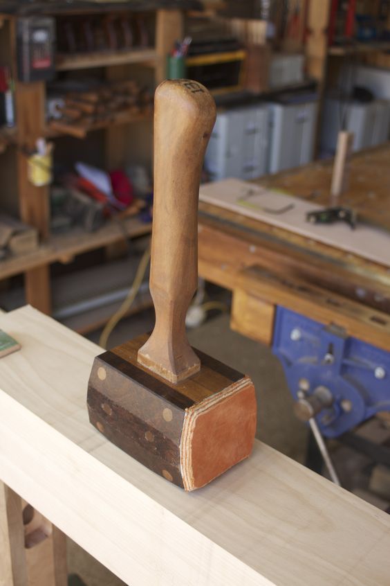 a piece of wood that is on top of a wooden bench in a shop with tools