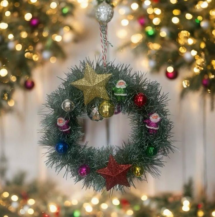 a christmas wreath hanging from the side of a wall with lights on it and decorations around it